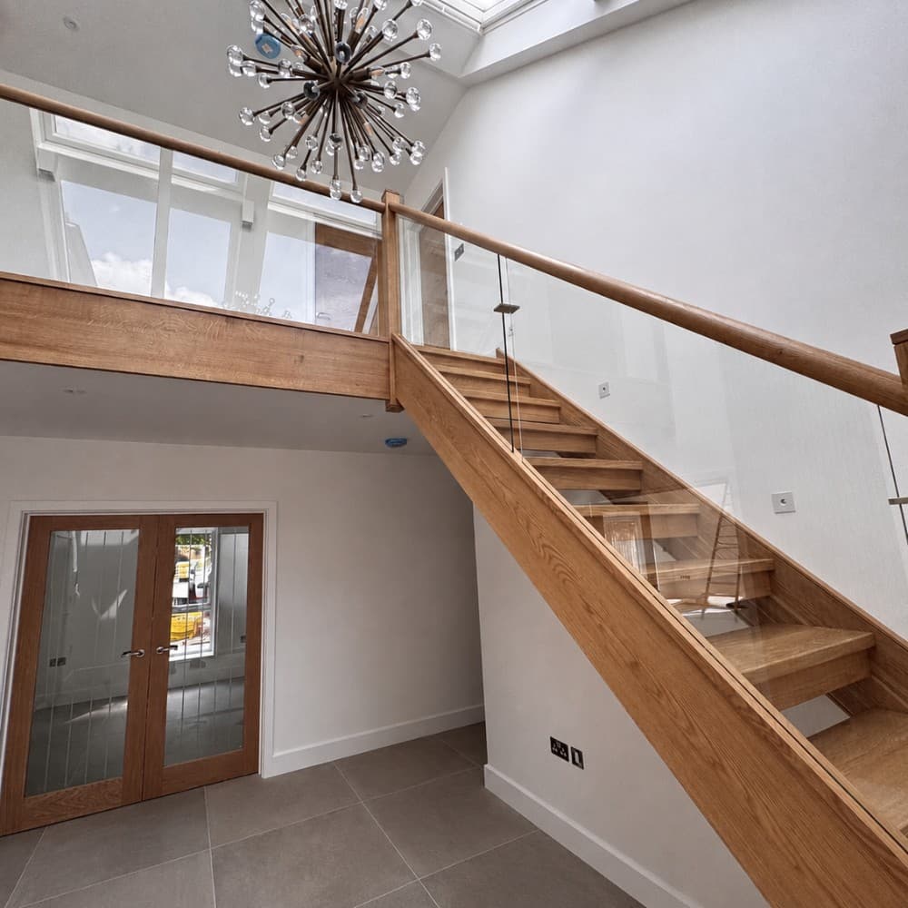 Frameless glass balustrades on a bespoke staircase by Devon Joinery